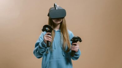 Woman using virtual reality headset with controllers indoors.
