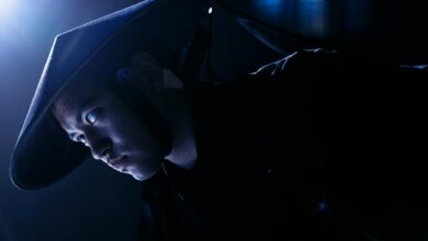 Dramatic low-key portrait of a cosplayer dressed as a game character, indoors, studio lighting.
