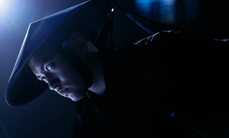 Dramatic low-key portrait of a cosplayer dressed as a game character, indoors, studio lighting.