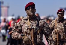 Armed Turkish commandos in camouflage gear marching outdoors during the day.
