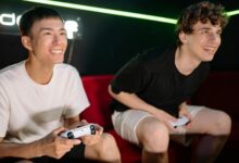 Two friends having fun playing video games indoors, captured in a lively and engaging moment.
