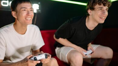 Two friends having fun playing video games indoors, captured in a lively and engaging moment.