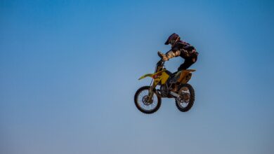Dynamic motocross jump featuring a rider in full gear under a clear sky.