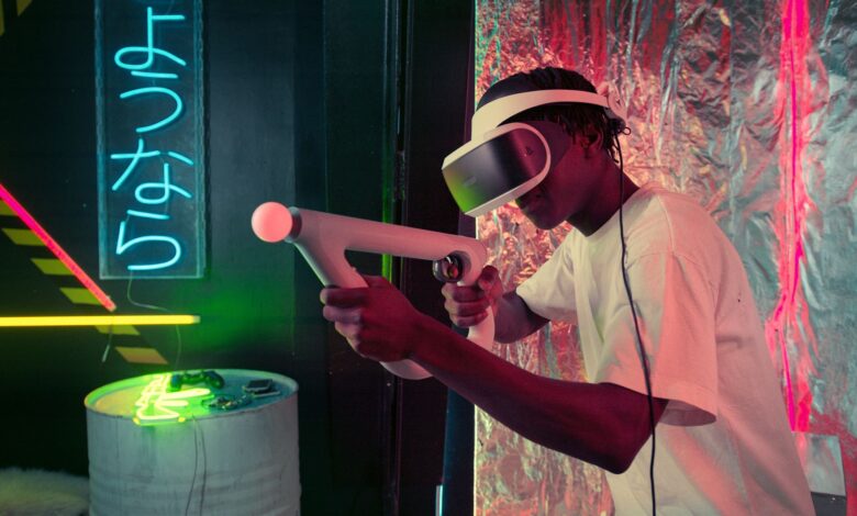 An adult enjoys virtual reality gaming with neon lighting and modern equipment.
