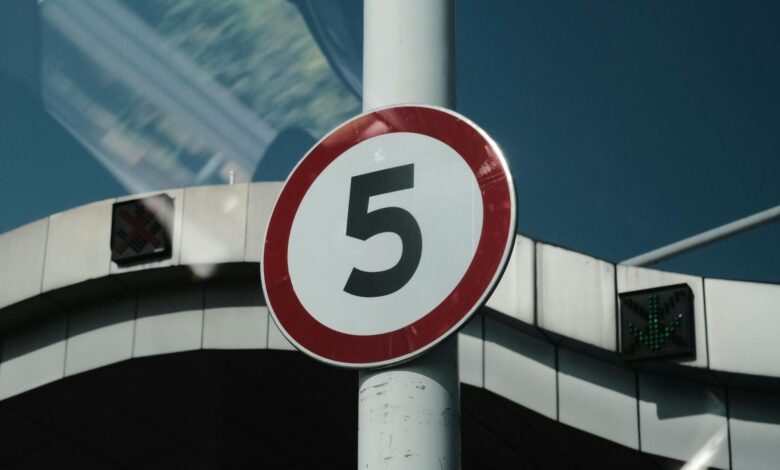 Close-up of a speed limit sign on a street pole in an urban setting.