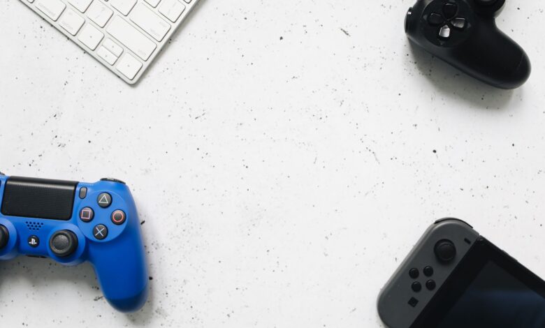 A variety of game controllers and a keyboard arranged on a white textured surface, offering a minimalist gaming setup.