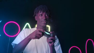 Serious young man playing video games in a neon-lit environment, focused and immersed.