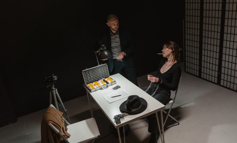 A tense indoor interrogation scene depicting a suspect and law enforcement setup.