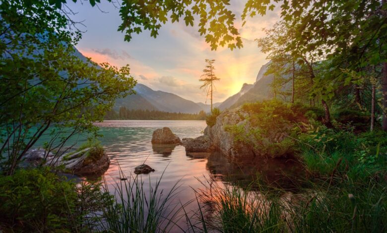 Peaceful mountain lake view with vibrant sunset and serene nature reflection.