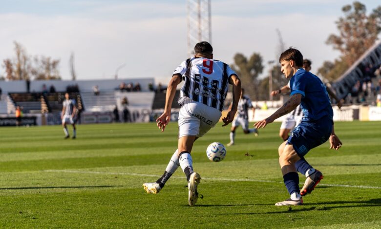 Players in action on the soccer field during an outdoor match under the bright sun.
