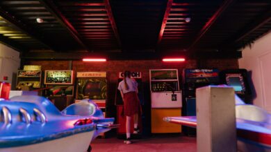 A teenager with pigtails plays classic arcade games in a vintage setting.