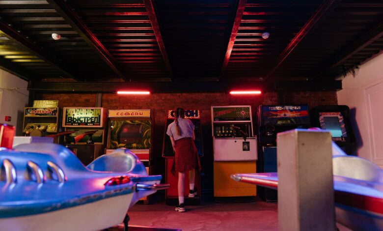 A teenager with pigtails plays classic arcade games in a vintage setting.