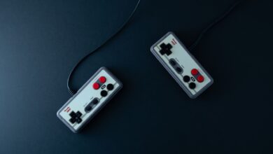 Top view of two retro gaming controllers on a minimalist dark background.