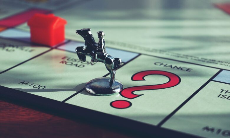 Close-up of a Monopoly board with a token and house, capturing classic board game elements.
