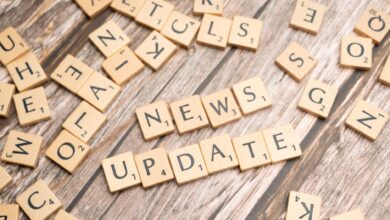Scrabble tiles spelling 'News Update' on a wooden background, ideal for media and communication concepts.