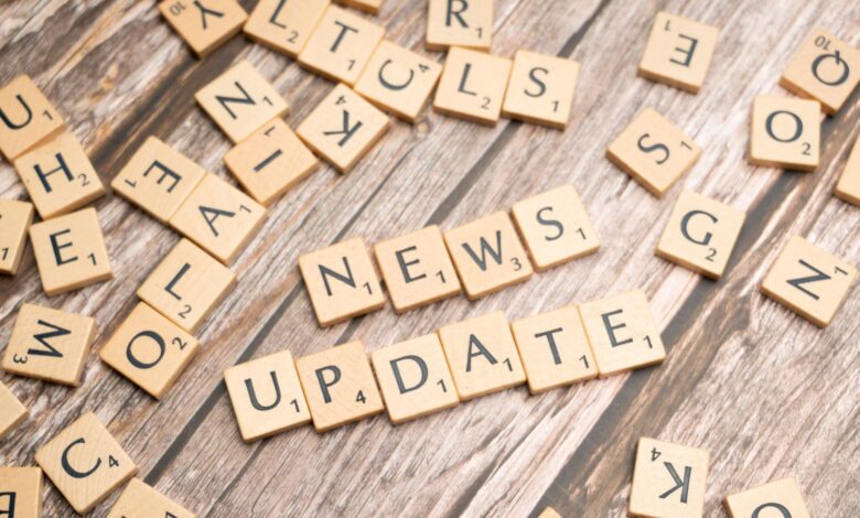 Scrabble tiles spelling 'News Update' on a wooden background, ideal for media and communication concepts.