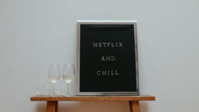 Minimalist scene with a 'Netflix and Chill' board and wine glasses on a wooden stool.