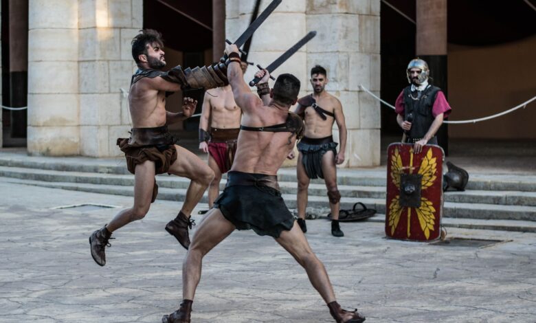 Intense scene of gladiators engaging in combat with swords in an ancient-style arena.