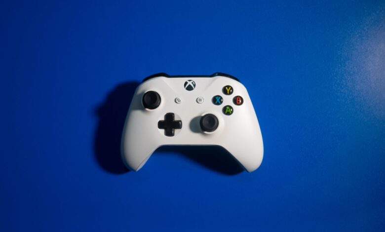 White wireless game controller on a vibrant blue backdrop, perfect for gaming-related content.