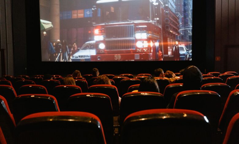 People seated in a cinema watching a movie on a large screen.