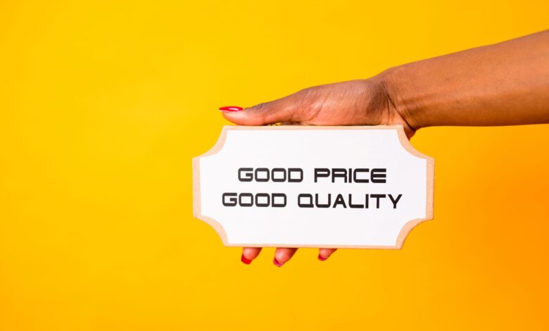 A hand holding a sign with 'Good Price Good Quality' against a vibrant yellow background.