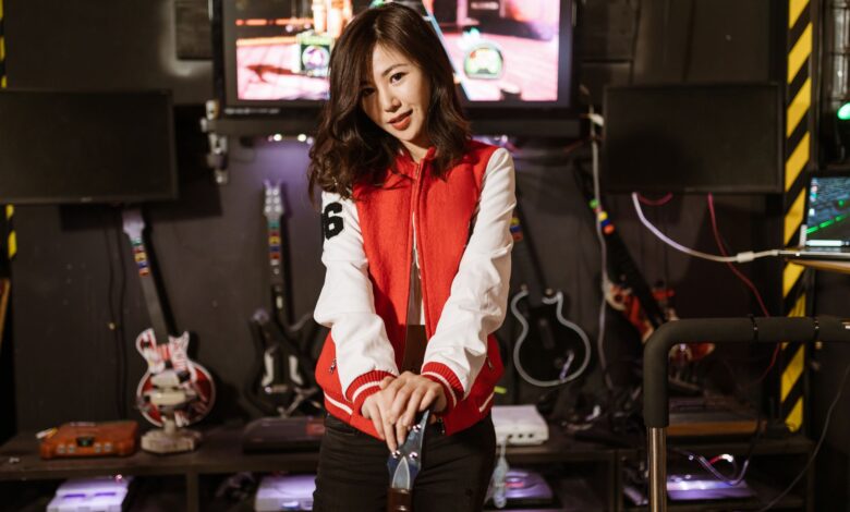 Young woman enjoying Guitar Hero session in a vibrant gaming lounge setting.