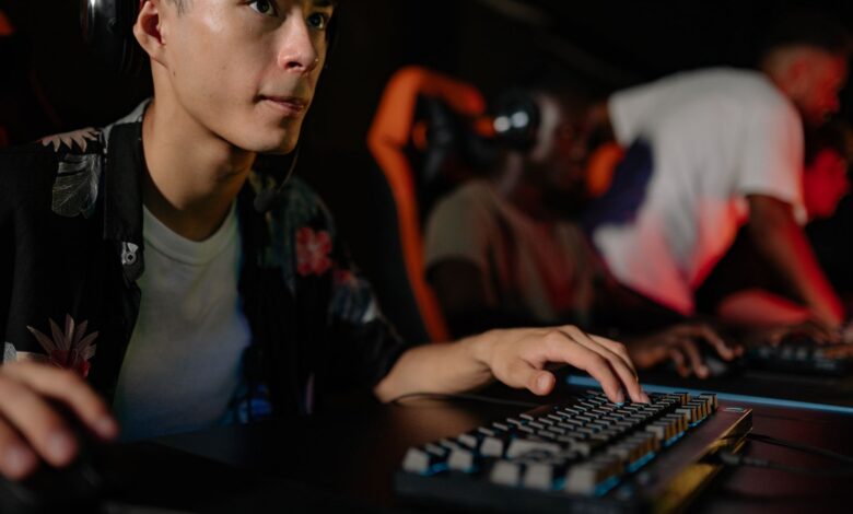 Young adults playing in a competitive esports tournament, deeply focused on gaming.
