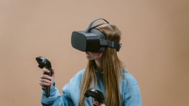 Woman using a VR headset and controllers, immersed in virtual reality gaming experience.