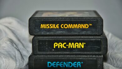 Close-up of vintage Atari game cartridges for Missile Command, Pac-Man, and Defender.
