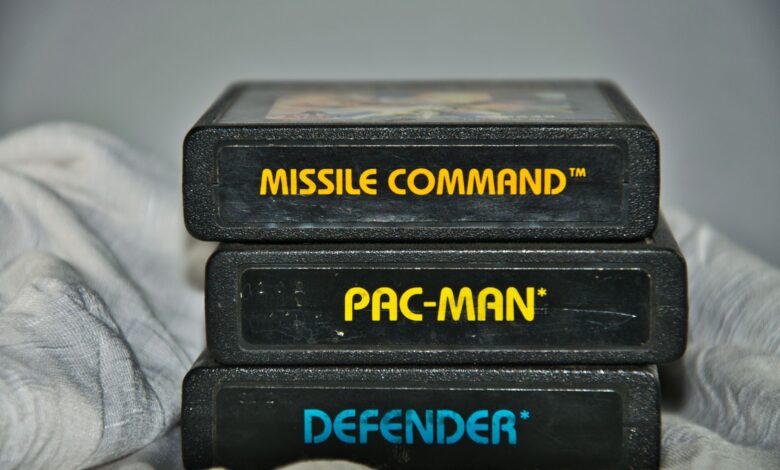 Close-up of vintage Atari game cartridges for Missile Command, Pac-Man, and Defender.