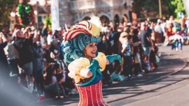 A lively performer in colorful costume entertains the crowd at a festival parade in Orlando.