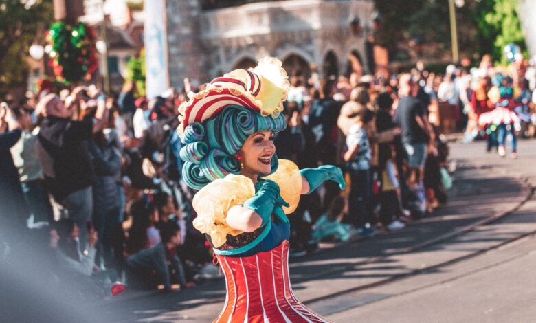 A lively performer in colorful costume entertains the crowd at a festival parade in Orlando.