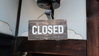 Weathered wooden closed sign hanging on a traditional Japanese building entrance.