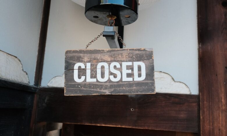Weathered wooden closed sign hanging on a traditional Japanese building entrance.