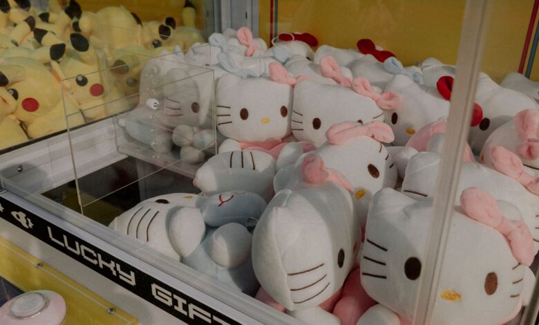 Claw machine featuring plush Hello Kitty and Pikachu toys, ideal for arcade entertainment.