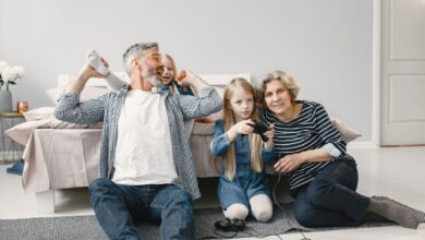 Family enjoying quality time playing video games together in a cozy bedroom.