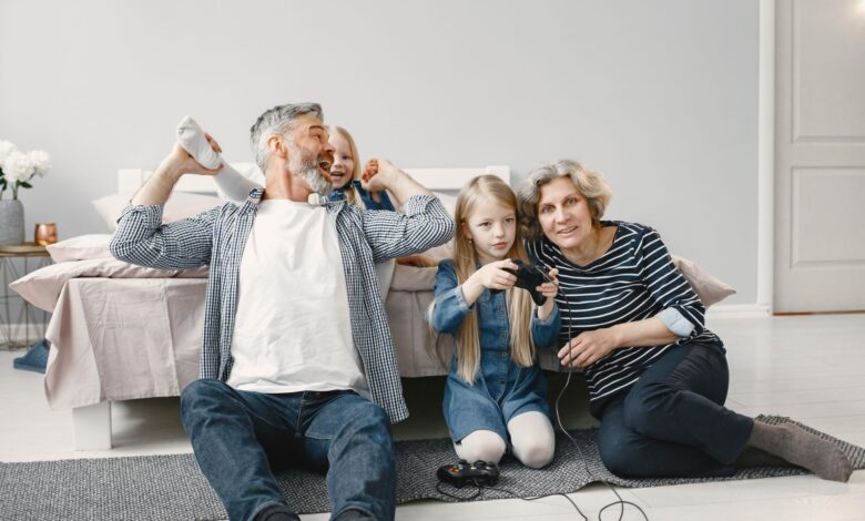 Family enjoying quality time playing video games together in a cozy bedroom.