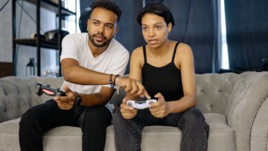 Two young adults enjoying video gaming together on a cozy couch at home.