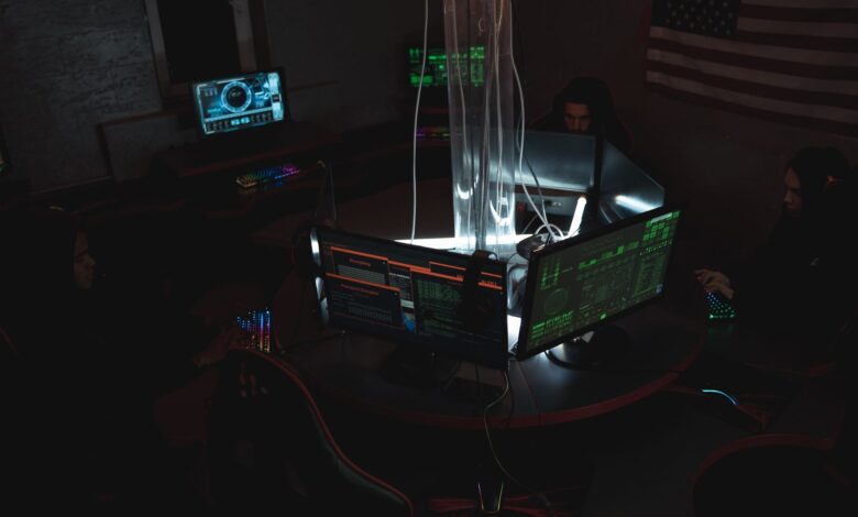 Team of cybersecurity experts collaboratively working on data protection in a dimly lit room filled with computers.