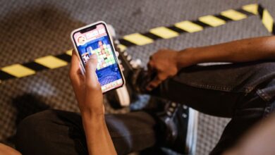 A person playing a colorful puzzle game on a smartphone while seated indoors.