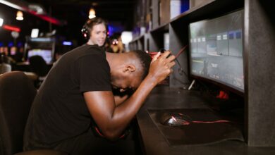 An adult male gamer shows frustration while playing a computer game in an esports arena.