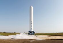 A SpaceX rocket prepares for launch in a rural landscape, capturing a sense of technological advancement.