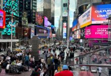 Dynamic scene in Times Square, New York City with colorful billboards and diverse crowd.