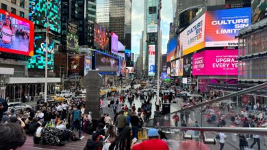 Dynamic scene in Times Square, New York City with colorful billboards and diverse crowd.