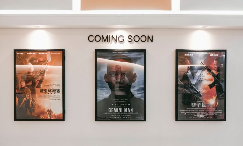 Framed posters of upcoming movies in a cinema hallway under 'Coming Soon' sign.