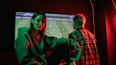 Two young adults playing video games intensely indoors with gaming controllers.