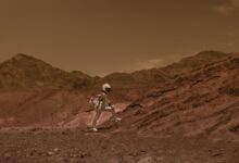 Astronaut in space suit walking through a Mars-like desert landscape, highlighting exploration and adventure.