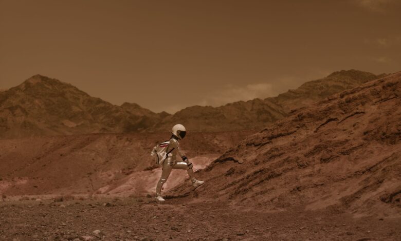Astronaut in space suit walking through a Mars-like desert landscape, highlighting exploration and adventure.