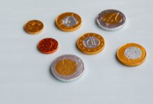 From above of different size chocolate euro coins placed on white surface