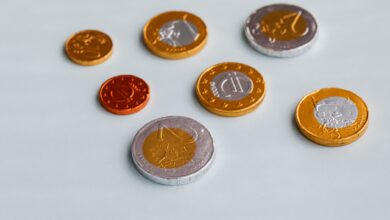 From above of different size chocolate euro coins placed on white surface